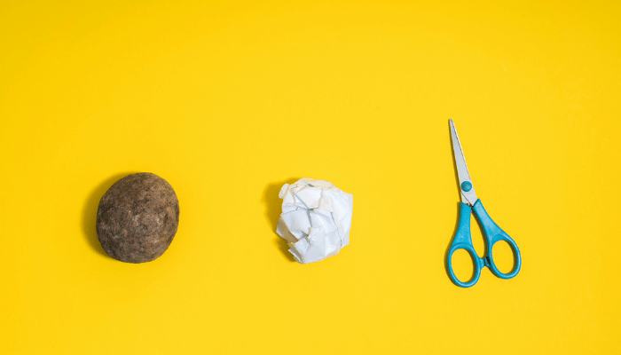 Yellow background with a rock, paper, and scissors